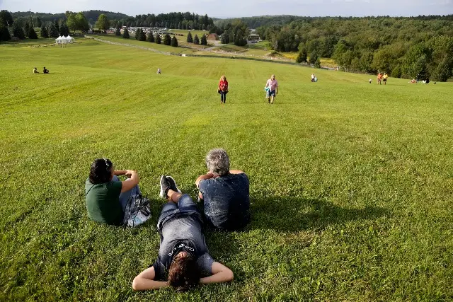 People hang out at the site of the original 1969 Woodstock Music and Arts Fair while waiting for the start of a 50th anniversary event nearby in Bethel, N.Y.